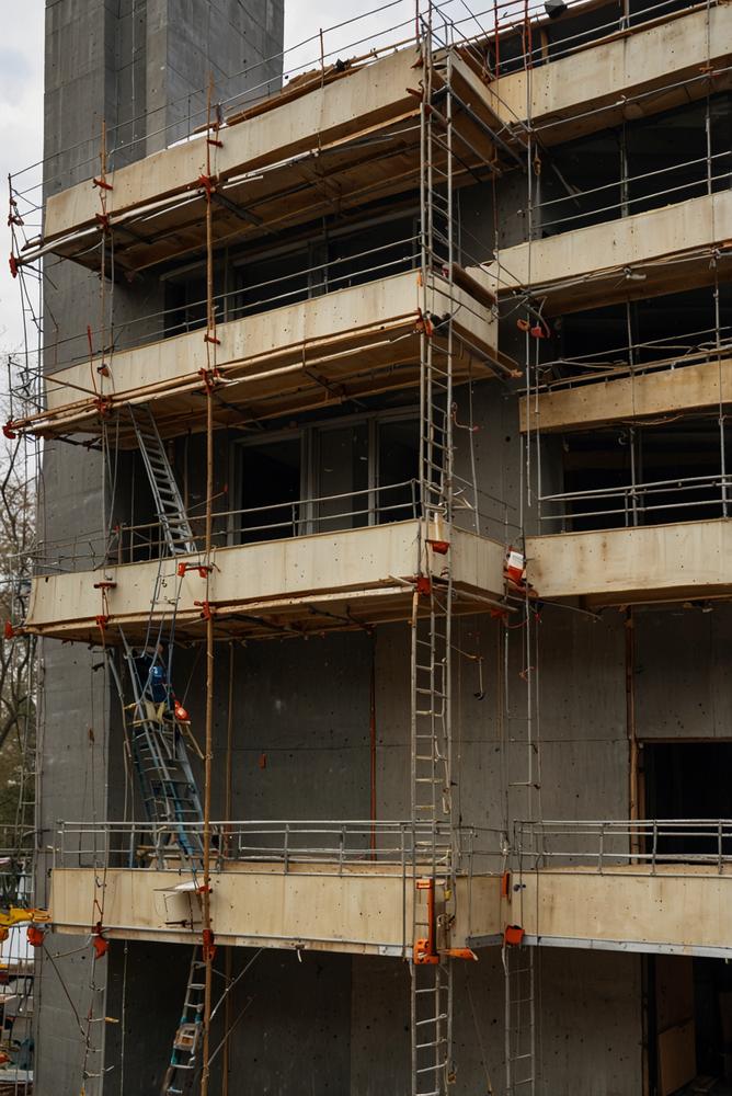 Helles Foto von sicher installiertem Geruest am Rohbau im Fruehling